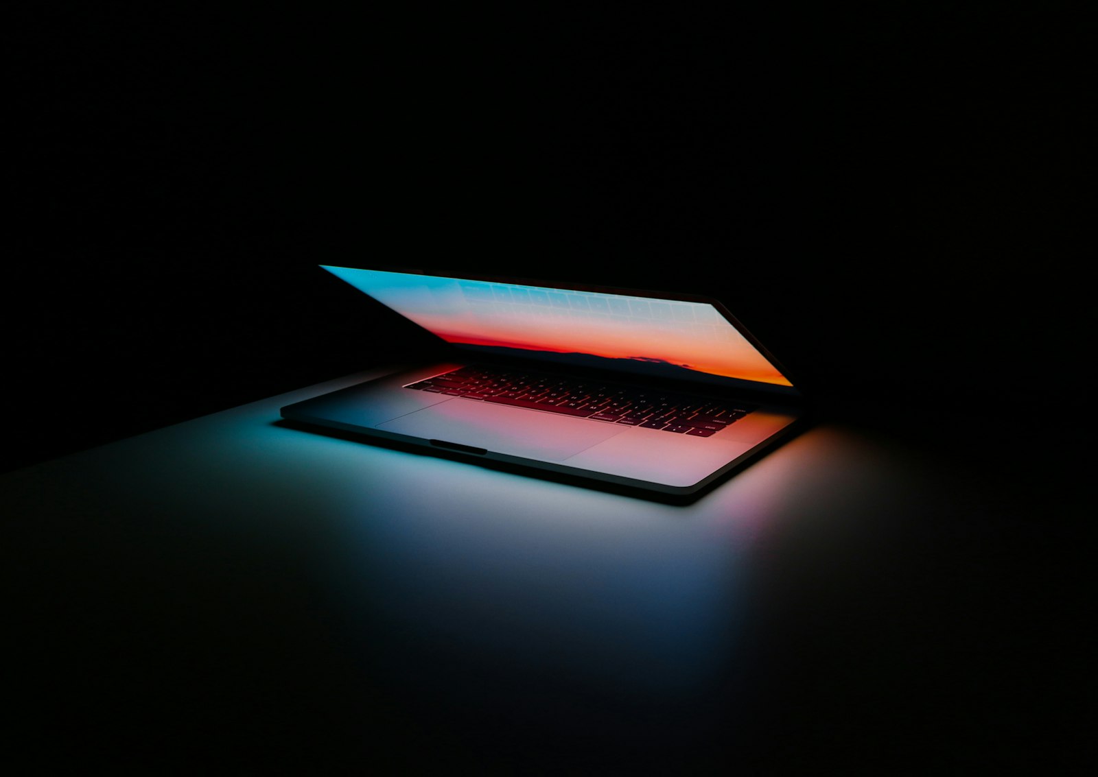 Modern workstation at night, lit by a screen showing color